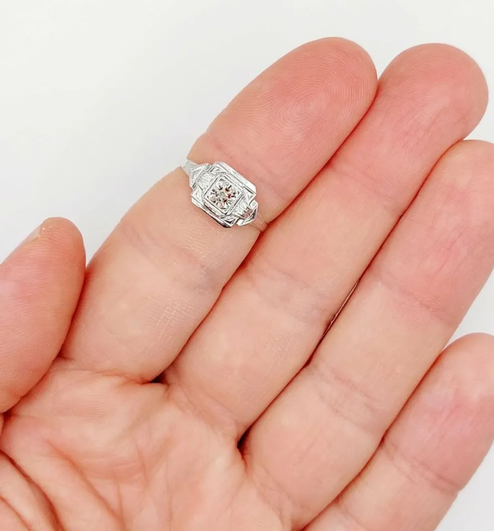 Bague art deco or blanc 18k ornée d'un diamant rond dans une monture géométrique finement travaillée (circa 1930)