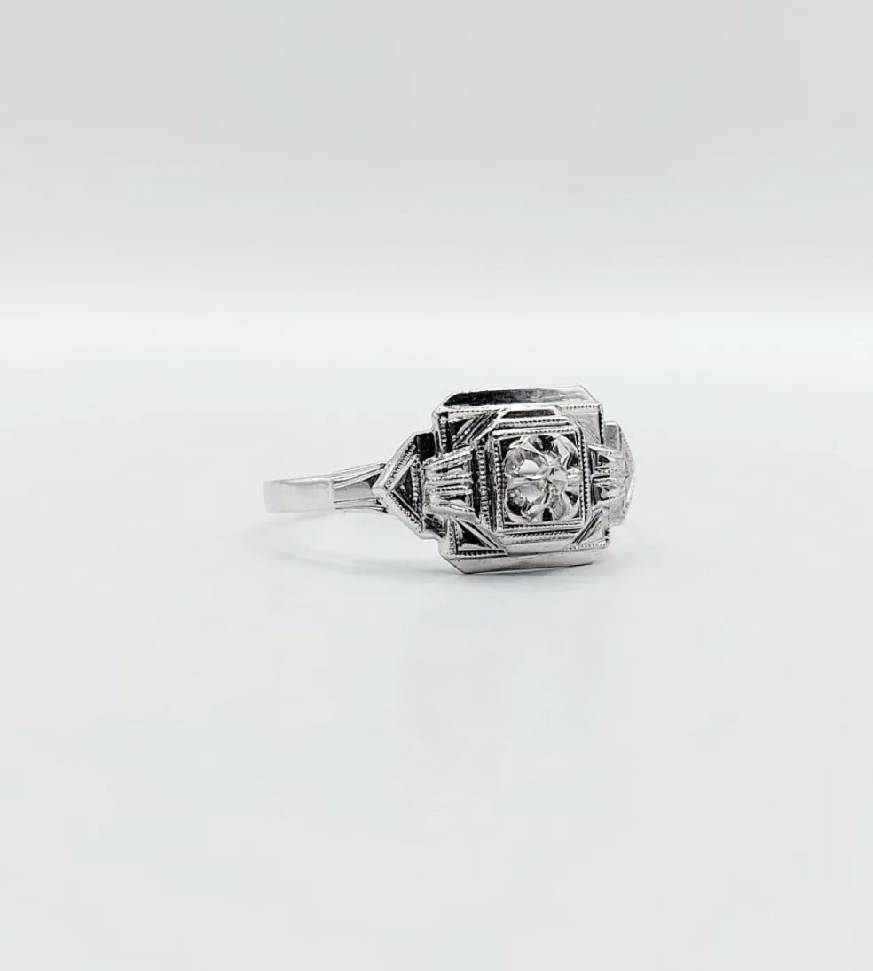 Bague art deco or blanc 18k ornée d'un diamant rond dans une monture géométrique finement travaillée (circa 1930)