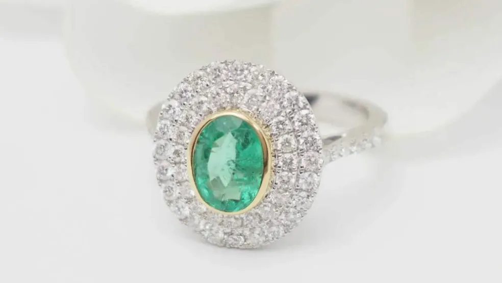 Bague double entourage en or bicolore, émeraude ovale et diamants