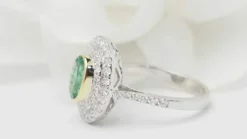 Bague double entourage en or bicolore, émeraude ovale et diamants