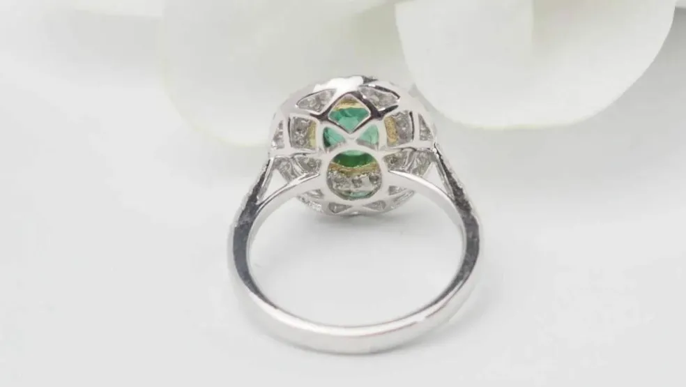 Bague double entourage en or bicolore, émeraude ovale et diamants