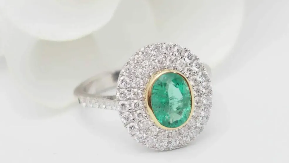 Bague double entourage en or bicolore, émeraude ovale et diamants