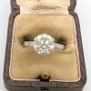 Bague en or blanc avec gros diamant central et diamants sur la tige
