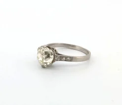 Bague en or blanc avec gros diamant central et diamants sur la tige