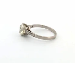 Bague en or blanc avec gros diamant central et diamants sur la tige