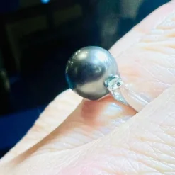 Bague en or blanc, perle de culture grise entourée de 2 diamants