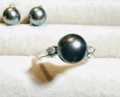 Bague en or blanc, perle de culture grise entourée de 2 diamants