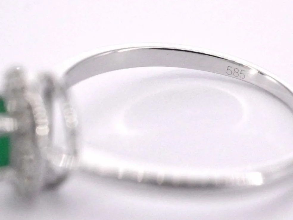 Bague entourage en or blanc avec diamants et émeraude