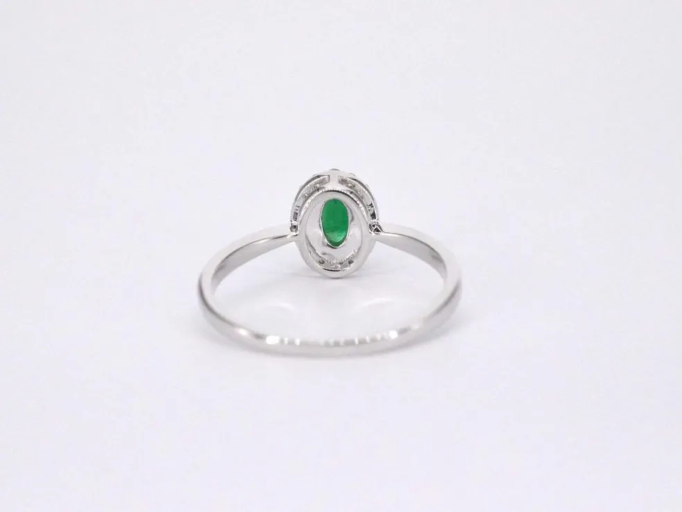 Bague entourage en or blanc avec diamants et émeraude