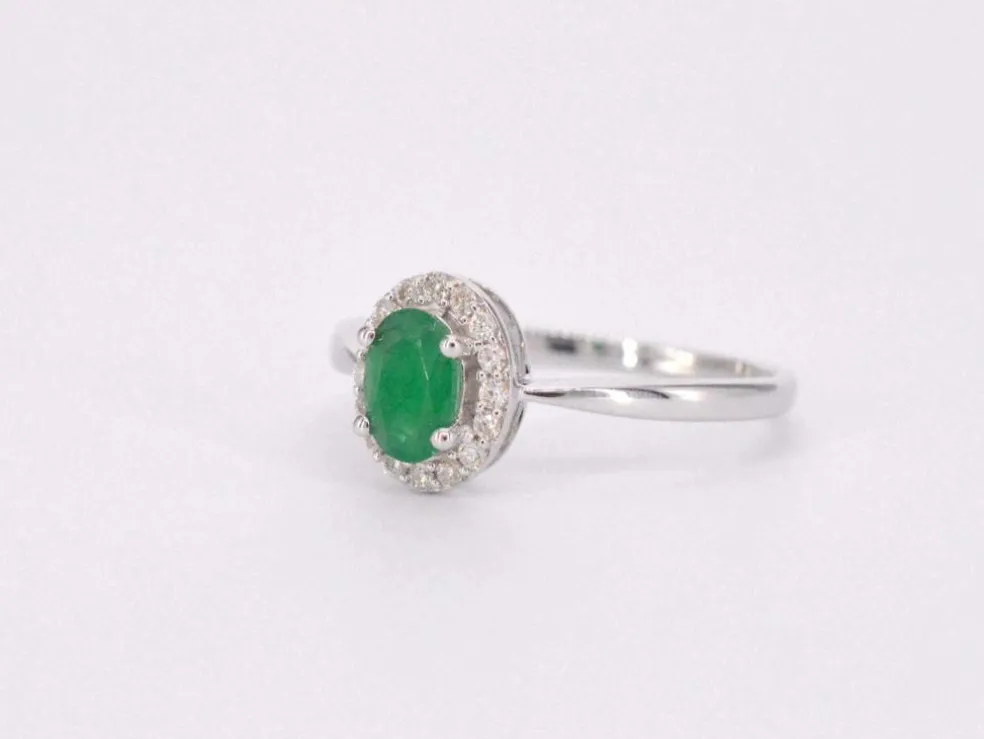 Bague entourage en or blanc avec diamants et émeraude