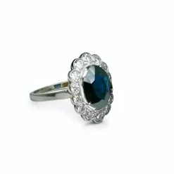 Bague marguerite en platine centrée d’un saphir entouré de diamants.
