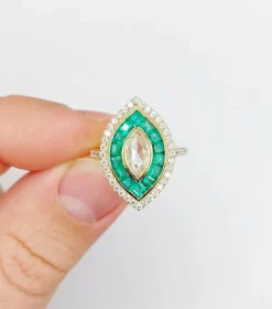 Bague marquise style art deco or jaune ornée de diamants entouré d'émeraude