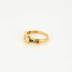 Bague or jaune centré d'un diamants, épaulée rubis, saphir, émeraude
