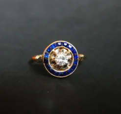 Bague ornée d'un Diamant, entourage de Saphirs calibrés