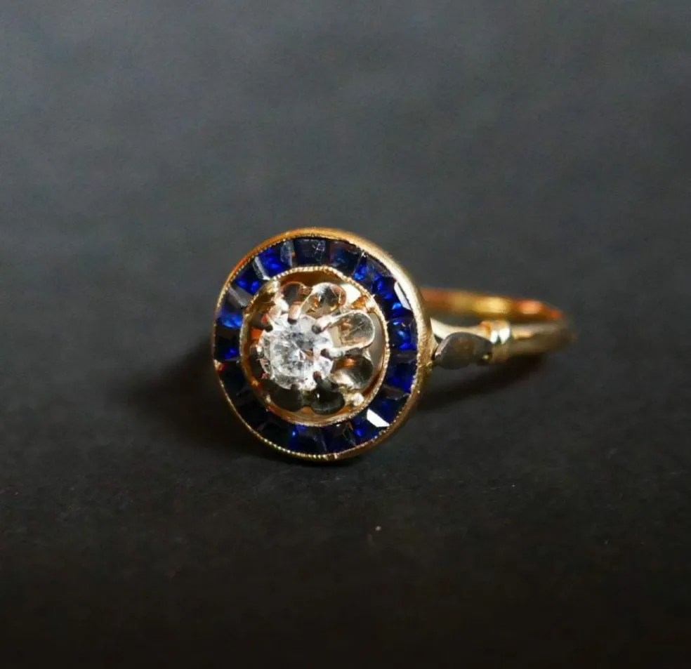 Bague ornée d'un Diamant, entourage de Saphirs calibrés
