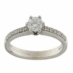 Bague solitaire en or blanc avec diamant central et diamants sur la tige