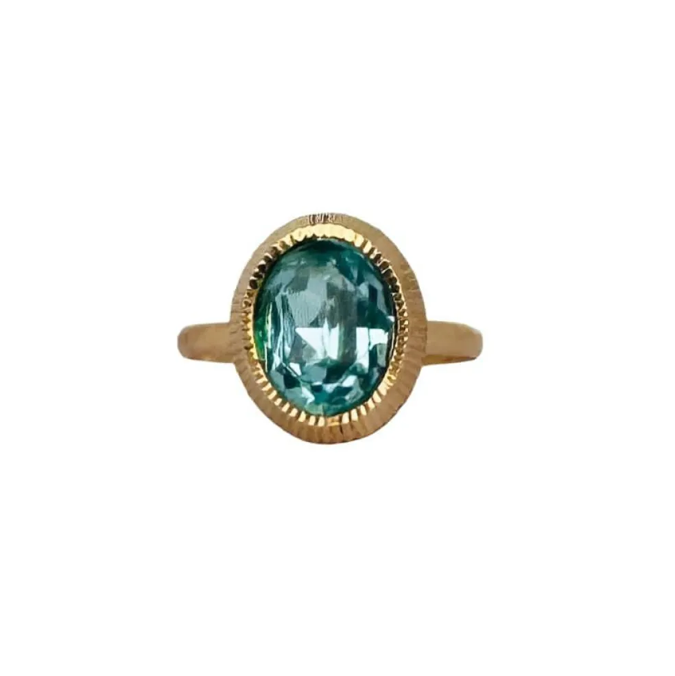 Bague solitaire en or rose avec topaze ovale bleue