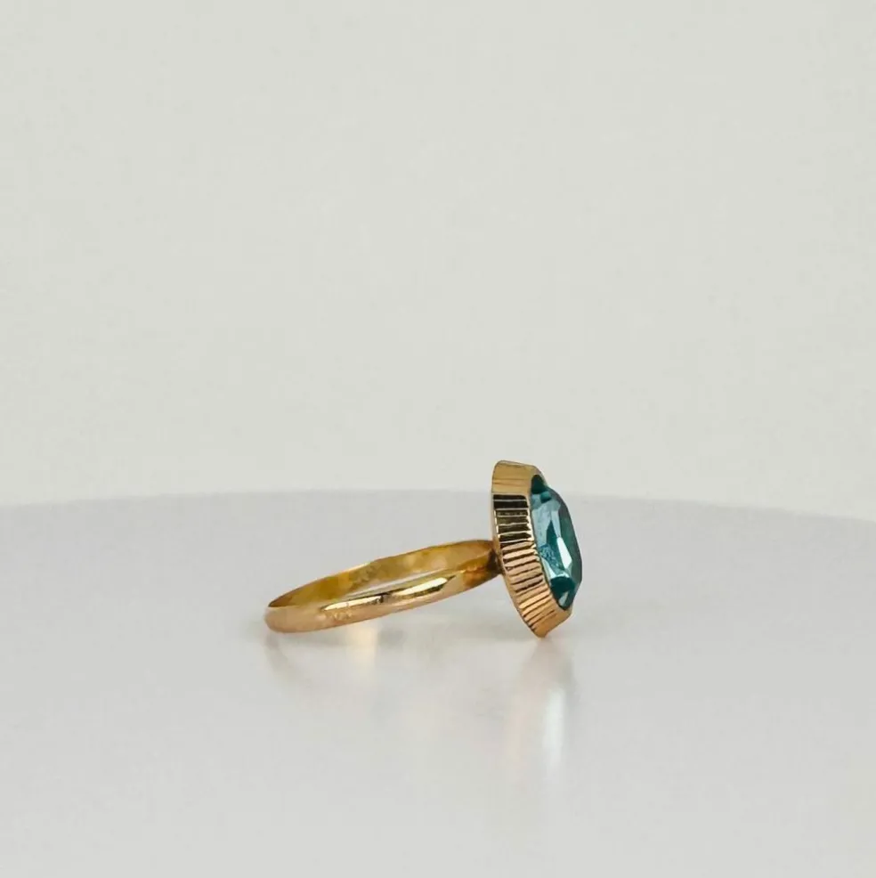 Bague solitaire en or rose avec topaze ovale bleue