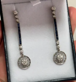 Boucles d'oreilles de style Art Déco en platine avec diamants et saphirs.
