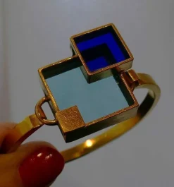 Bracelet en métal doré et plexis bleu clair et bleu foncé.