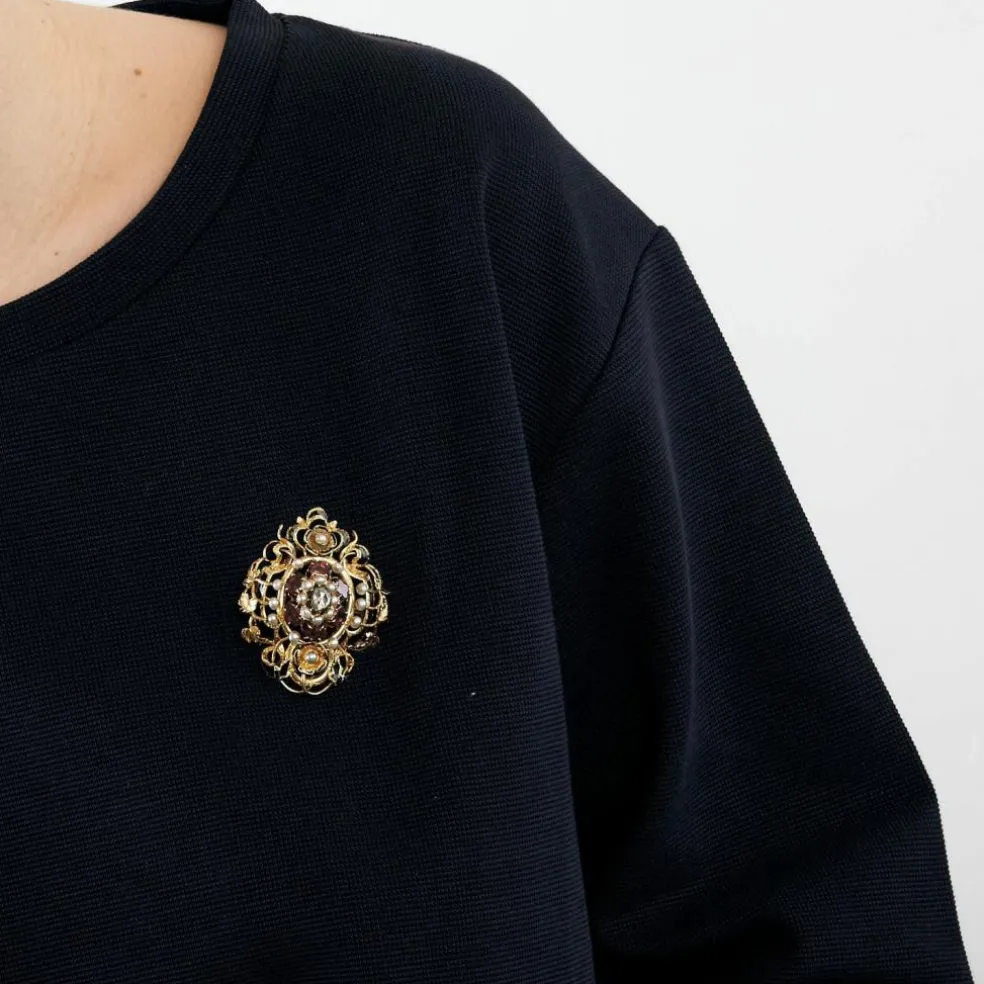Broche à décor de rinceau et fleurs avec émail noir, perles et grenats