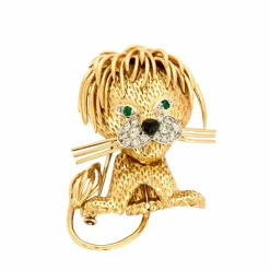 Broche Lion en or jaune et blanc, émeraudes, diamants et onyx