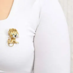 Broche Lion en or jaune et blanc, émeraudes, diamants et onyx