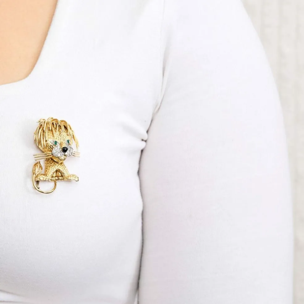 Broche Lion en or jaune et blanc, émeraudes, diamants et onyx