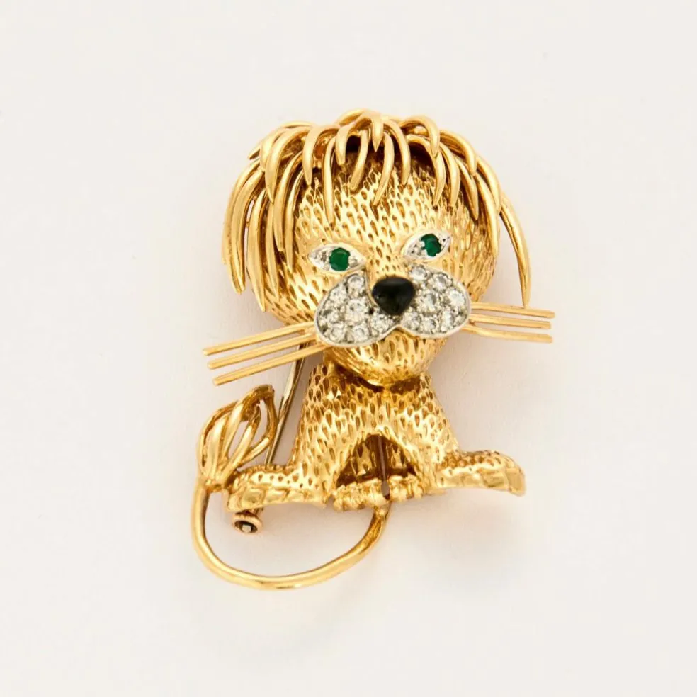 Broche Lion en or jaune et blanc, émeraudes, diamants et onyx