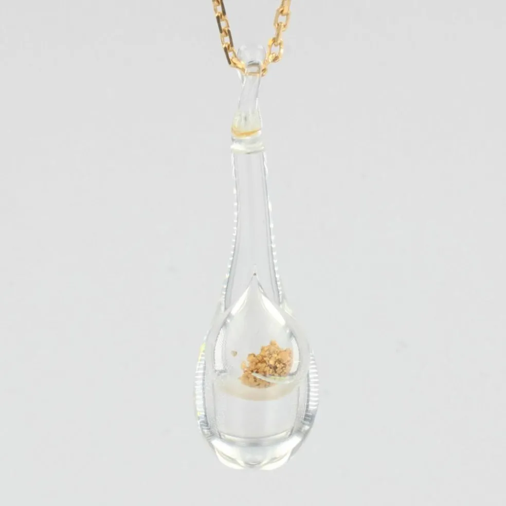 Chaîne en or et son pendentif en verre et paillettes dorées