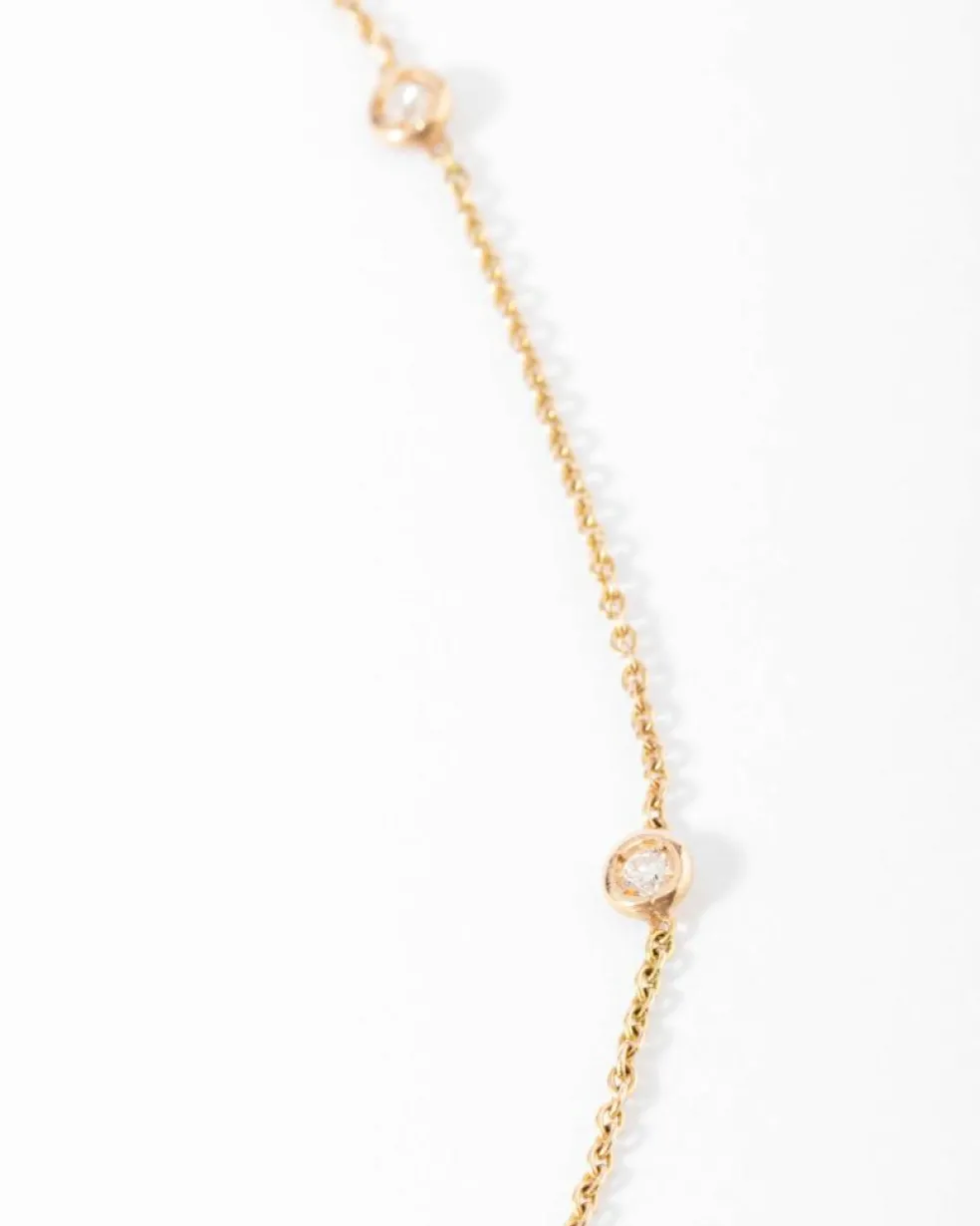 Collier or jaune intercalé de 9 diamants sur maille forçat en sertis clos.