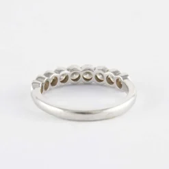 Demi alliance en or gris sertie clos, diamants