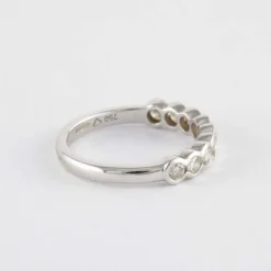 Demi alliance en or gris sertie clos, diamants