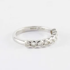 Demi alliance en or gris sertie clos, diamants
