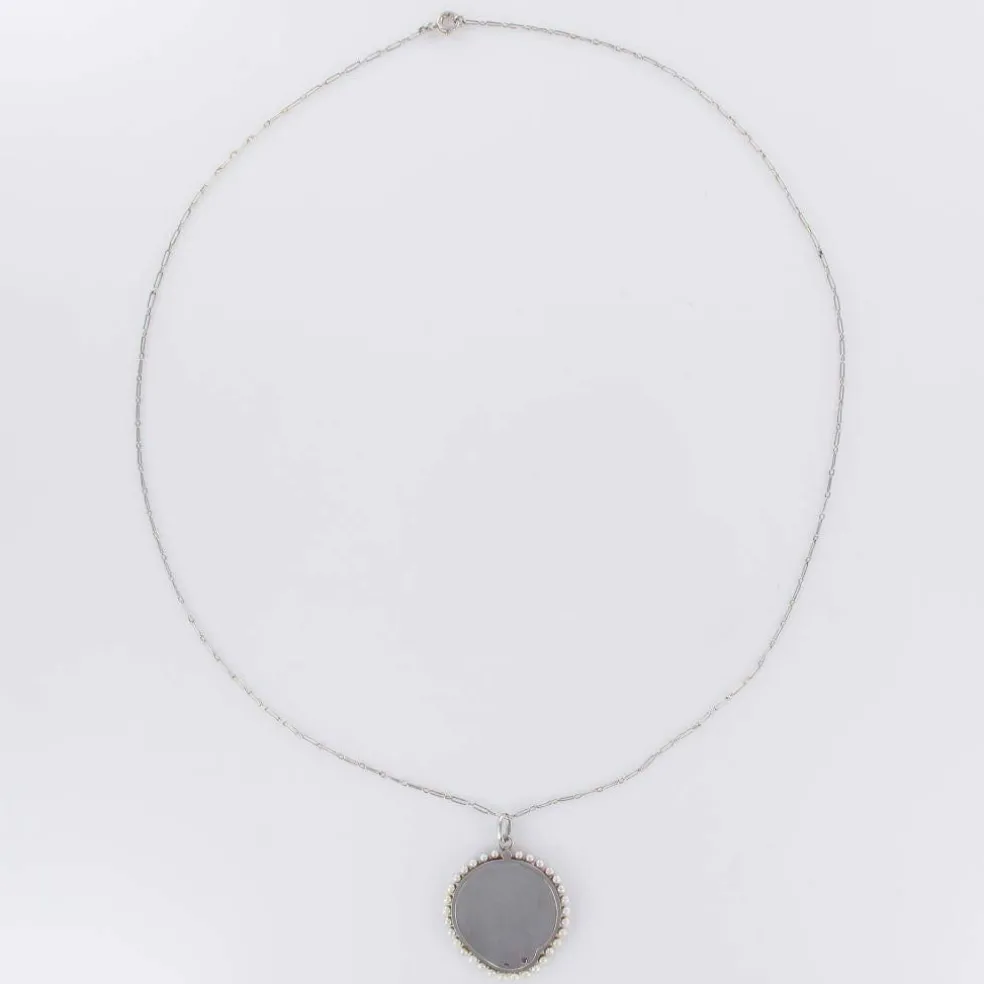 Médaille et sa chaine en platine, nacre et perles fines