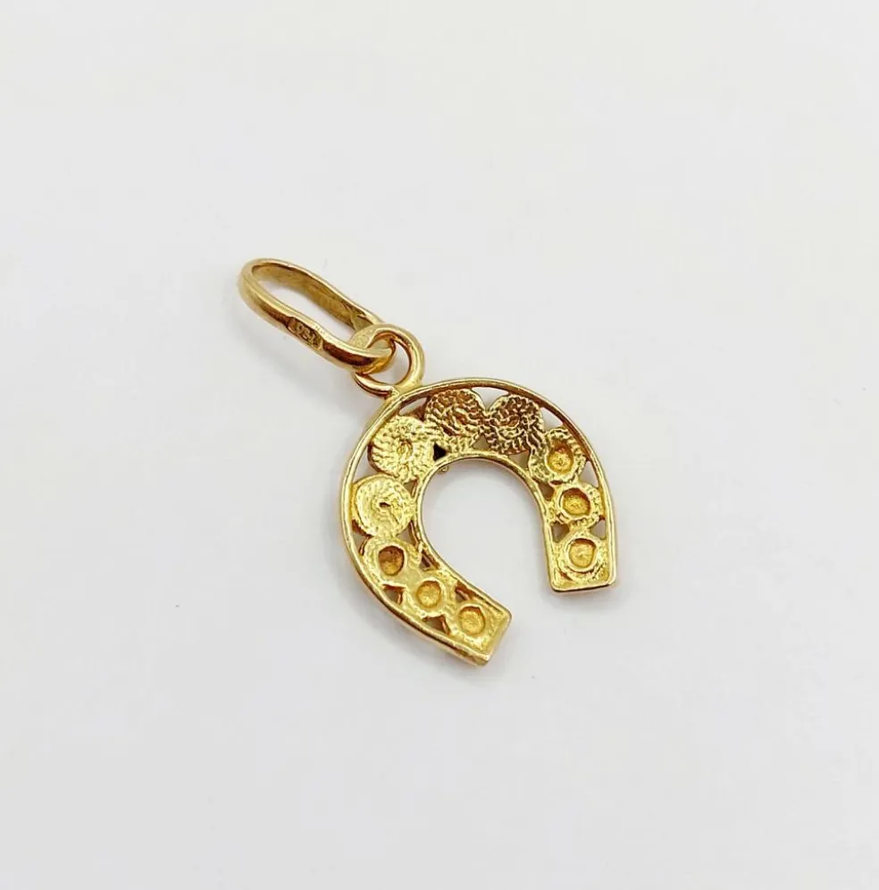 Pendentif vintage or jaune représentant un fer à cheval finement décoré