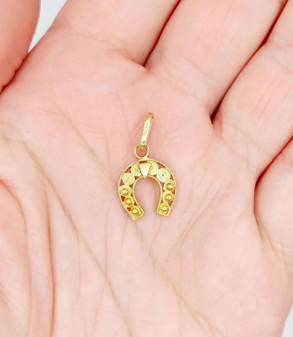Pendentif vintage or jaune représentant un fer à cheval finement décoré